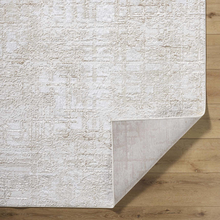 Close-up of the Auriel Beige Area Rug showing its textured, contemporary design and neutral color palette on wood floors. Fold