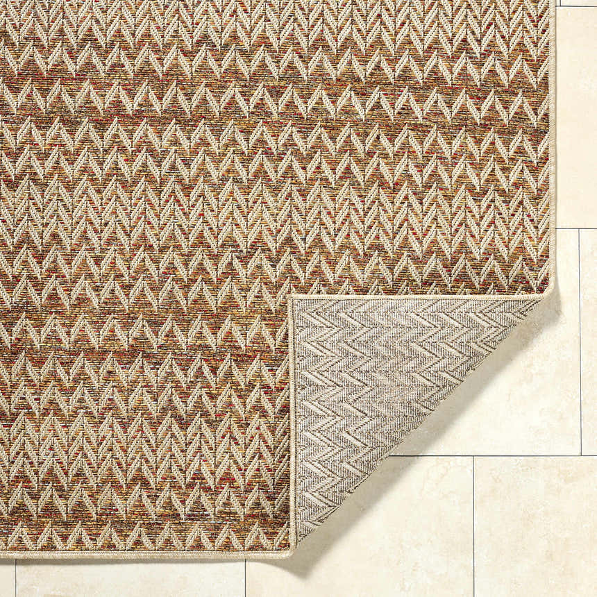 Close-up of Alazne Burnt Orange Area Rug showing a cream, sandstone, and terracotta chevron pattern and the rug's backing. Fold