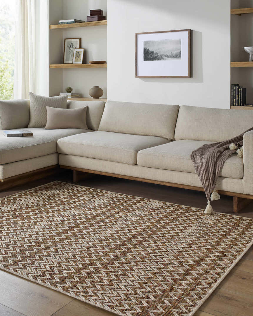 Living room scene with a neutral sectional sofa and the Alazne Burnt Orange Area Rug with a geometric pattern. Roomscene-Rectangle
