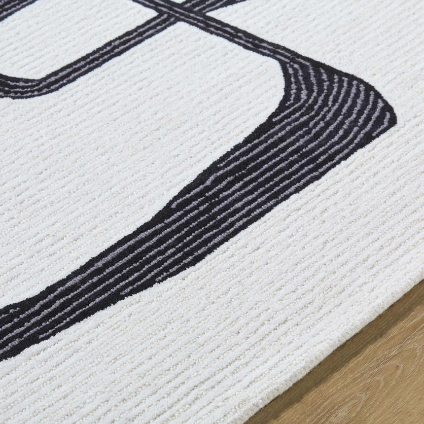 Close-up of the Ulfah Area Rug. Hand-tufted wool rug in ash and jet black with a contemporary geometric design. Texture