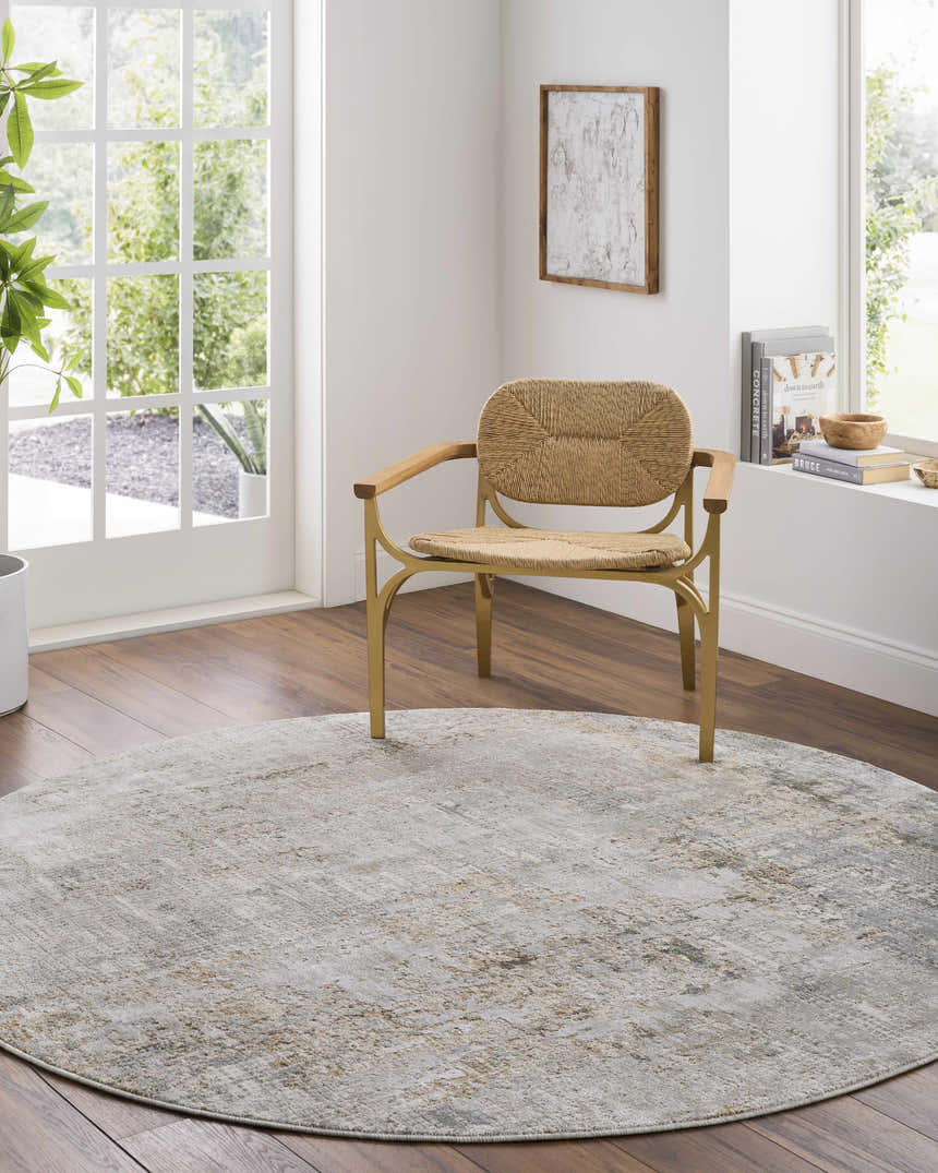 Light-filled room with a round Marli Thick Luxe Area Rug in gray and brown, paired with a woven chair on wood floors. Roomscene-Round