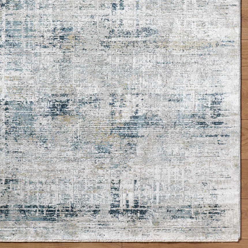 Close-up of the Neron Thick Luxe Abstract Rug. Features a blue, charcoal, cream, and gray Southwestern-style pattern. Corner