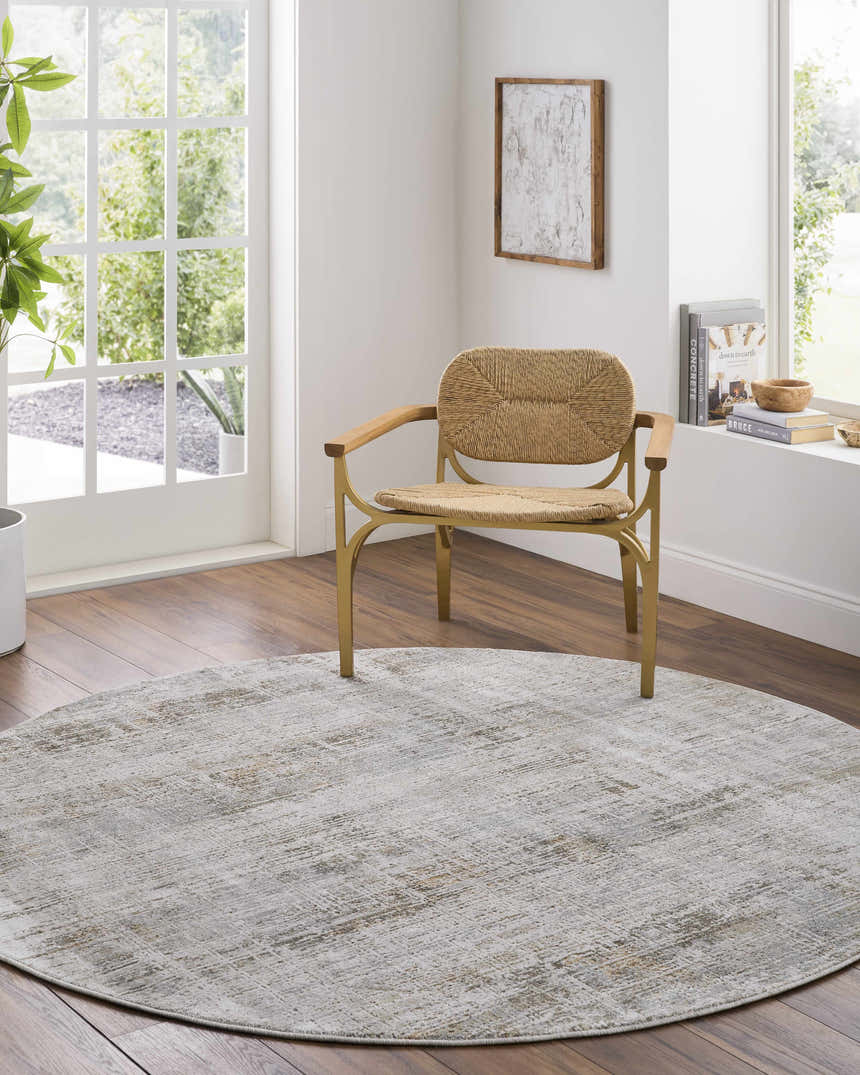 Sunlit room with a round Neron Blue Gray Thick Luxe Abstract Rug, woven chair, and wood floors. Roomscene-Round