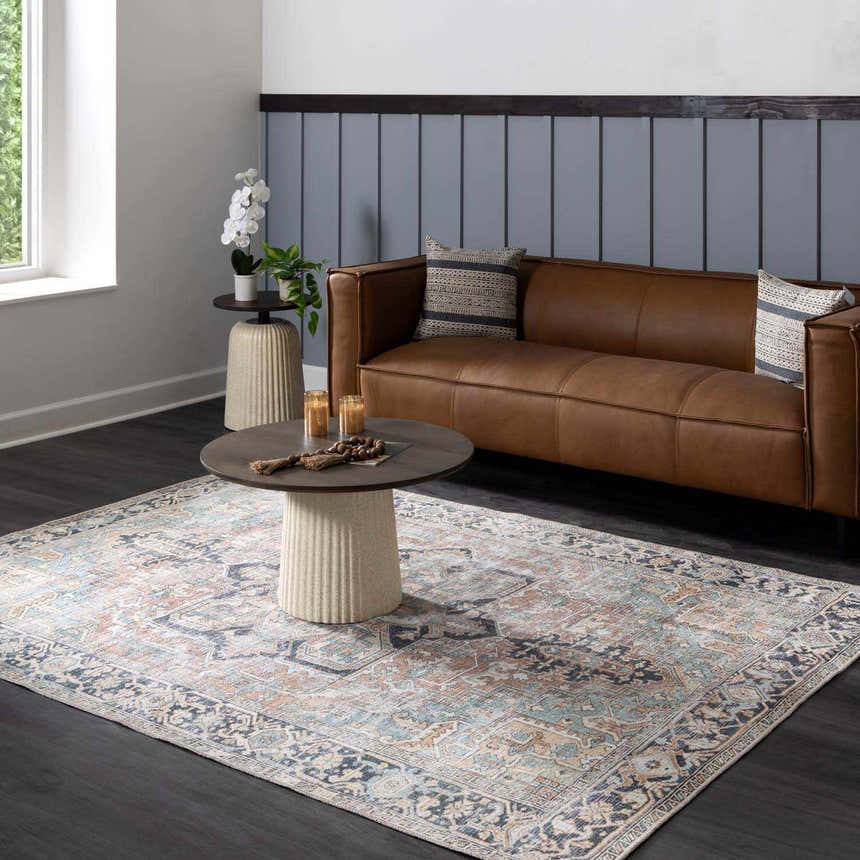 Living room scene with a brown leather sofa and the Green Nisa Tumble Dry Washable Rug in brick red, navy, and seafoam. Roomscene-Rectangle