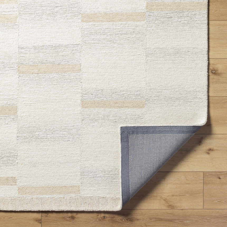 Close up of Max Handmade Becki Owens x LIVABLISS rug. Cream, ivory, and tan geometric pattern. Hand-tufted wool texture. Fold