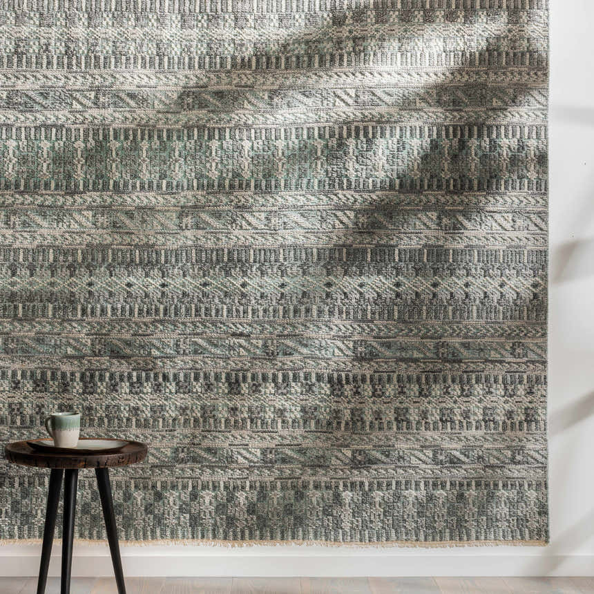 Close-up of the Normanhurst Area Rug. Hand-knotted wool and viscose rug in charcoal, ivory, light gray, and sage with bohemian pattern. Styleshot