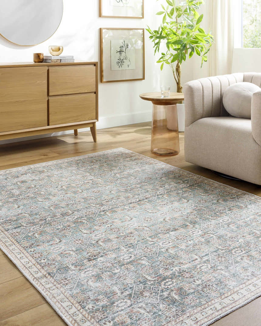 Living room scene with the Ayanna Washable Area Rug in cream, teal, and red tones, styled with a light wood cabinet and cream armchair. Roomscene-Rectangle