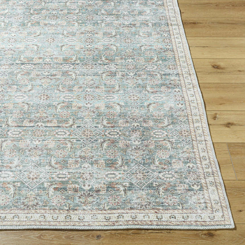 Close-up of Ayanna Washable Area Rug. Traditional design in cream, teal, tan, and dark red on wood floor. Front