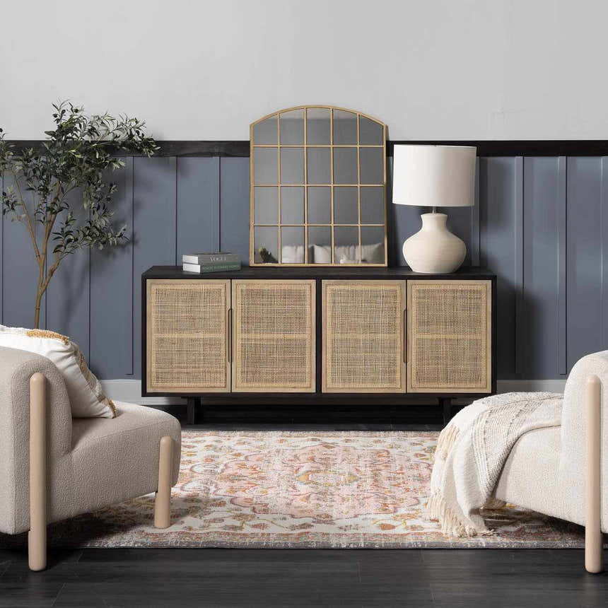 Living room scene with Oark Floral Medallion Area Rug in brick red and pink tones, styled with a rattan cabinet and cream armchairs. Roomscene-Rectangle