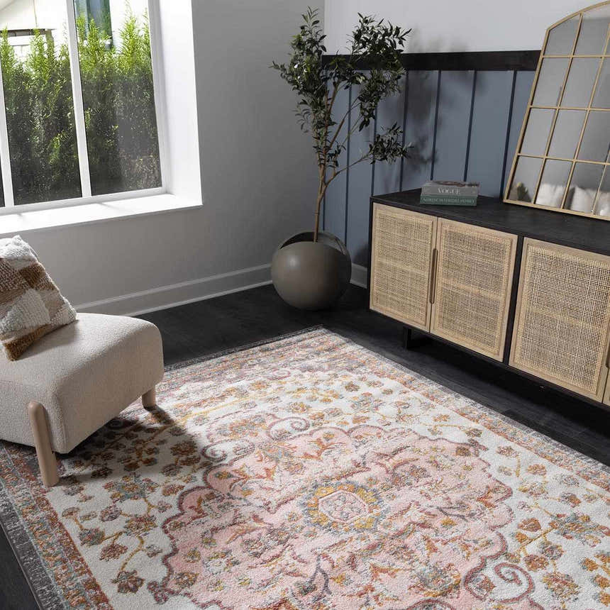 Living room scene with a pink Oark Floral Medallion Area Rug, beige chair, and rattan cabinet. Modern bohemian style. Roomscene-Rectangle