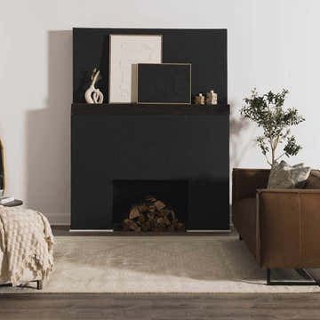 Living room scene with Paloma Area Rug, black fireplace, brown leather chair, and hardwood floors. Roomscene-Rectangle