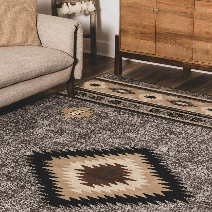 Living room scene with a Buckhaven area rug in brown, beige, and black with a Southwestern pattern. Roomscene-Rectangle