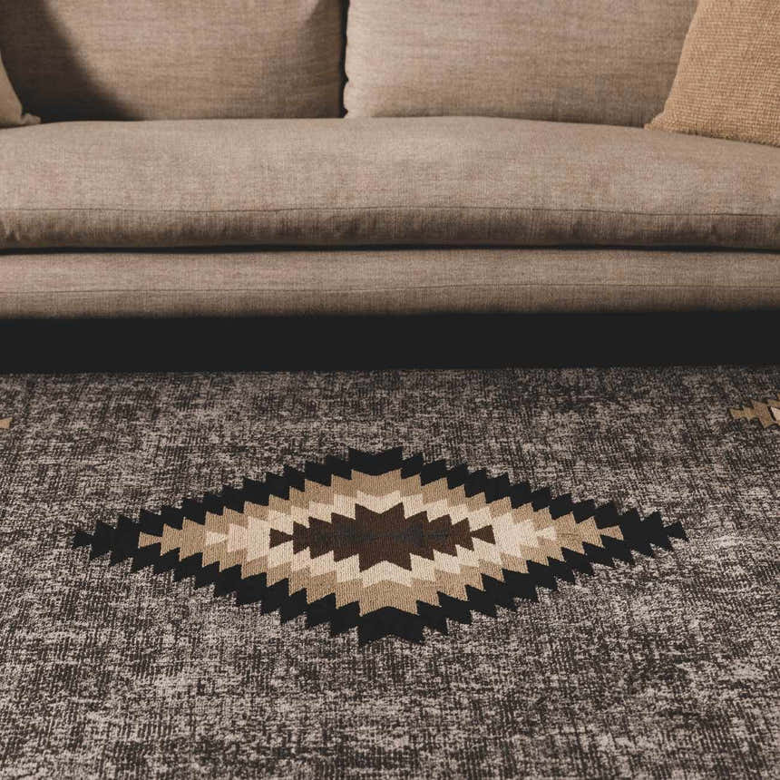 Living room scene with beige sofa and the Buckhaven Area Rug featuring a geometric diamond pattern. Roomscene-Rectangle