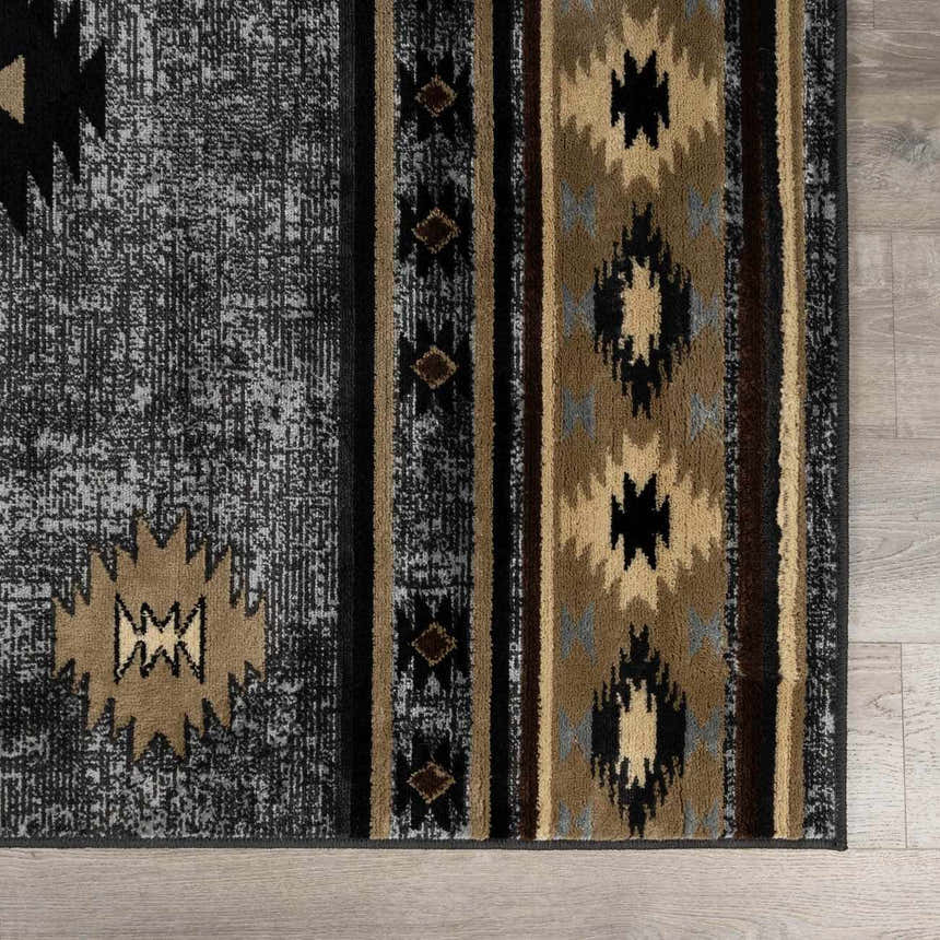 Close-up of the Buckhaven Area Rug featuring a Southwestern-inspired geometric pattern in black, gray, and tan. Swatch