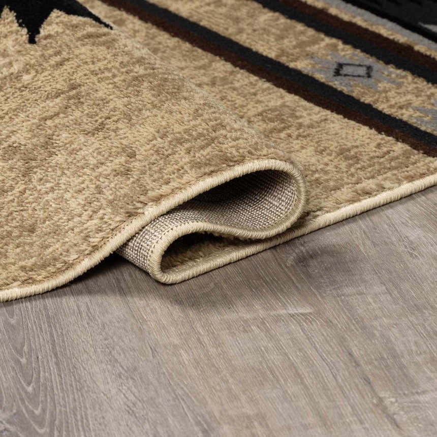Close-up of the Buckhaven Brown Aztec Carpet showing its beige, brown, and black geometric pattern and soft, textured pile. Fold