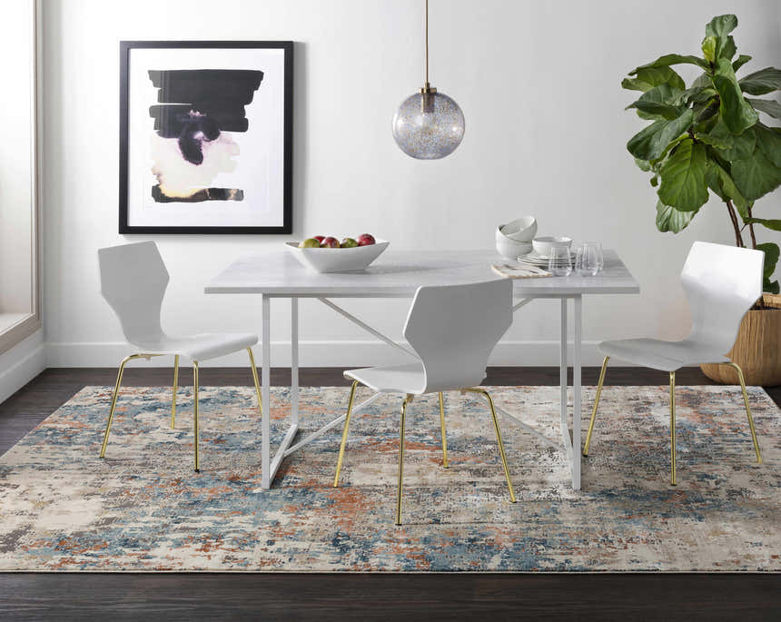 Dining room with Priscilla Area Rug in burnt orange, blue, and beige. Modern white table and chairs. Roomscene-Rectangle