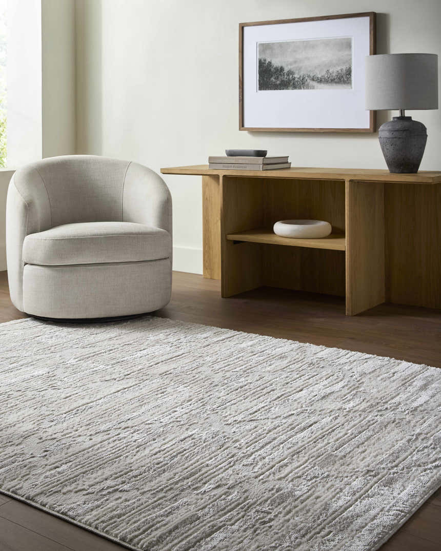 Neutral living room with cream chair and light wood console table featuring the Akilah Area Rug. Roomscene-Rectangle
