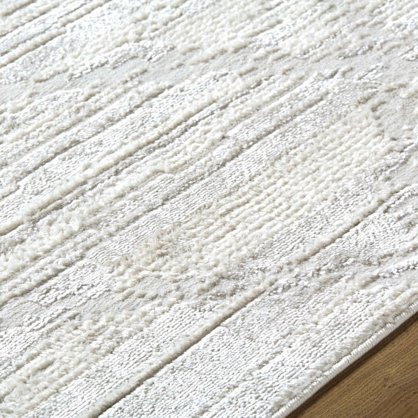 Close-up of the Akilah Area Rug. Cream and ivory rug with a subtle, contemporary striped pattern and soft texture. Texture