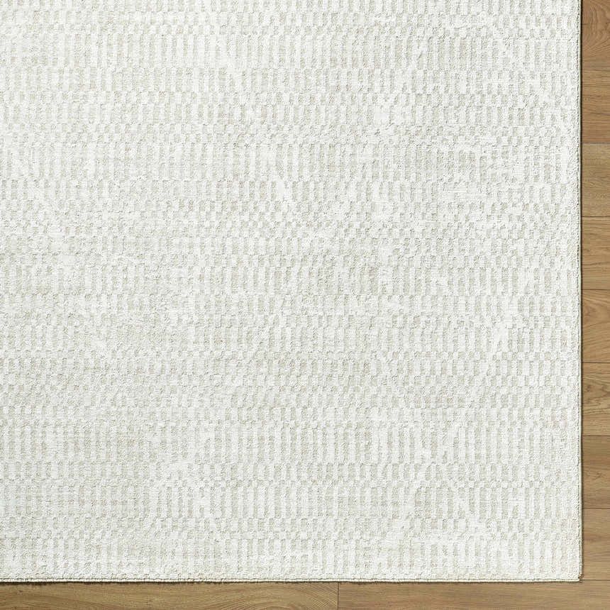 Close-up of the Pabla Cream Area Rug showing its ivory color and subtle geometric pattern. Corner