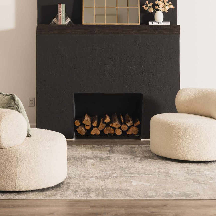 Living room scene with a Pialba Thick Luxe Abstract Smokey Rug, fireplace, and cream boucle chairs. Swatch