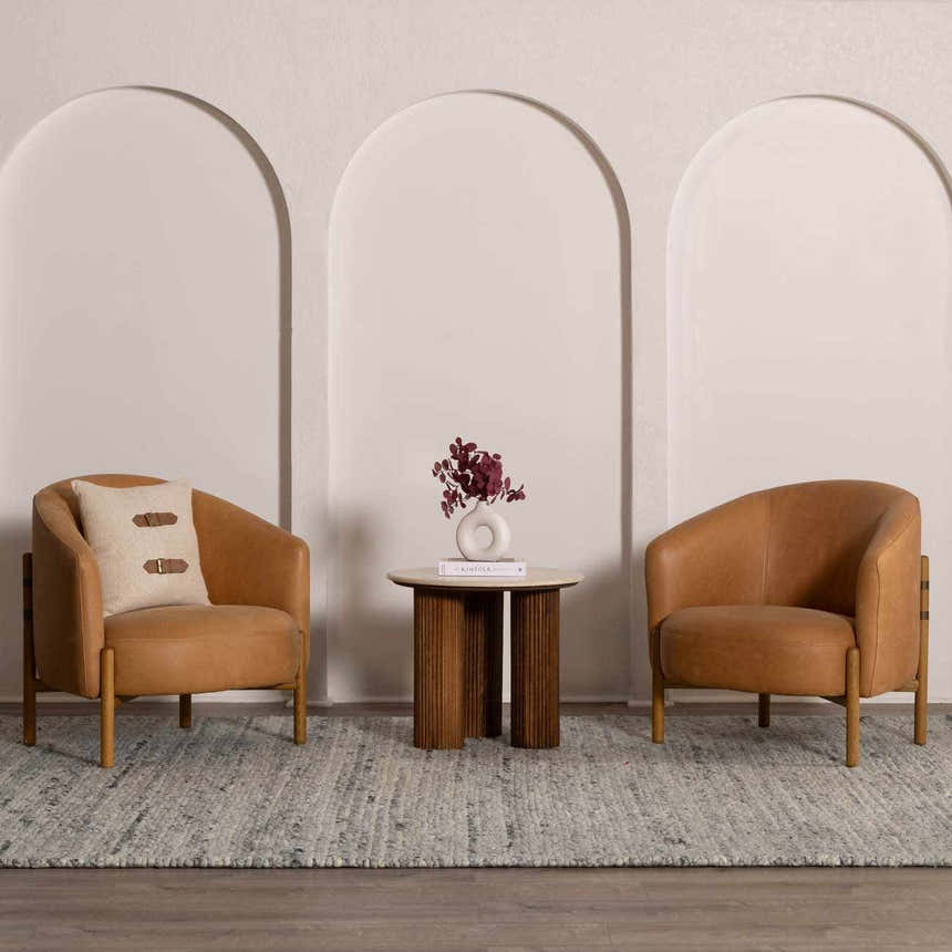 Living room scene with two leather chairs on the light gray Olisa Gray Wool Area Rug from Boutique Rugs. Roomscene-Rectangle