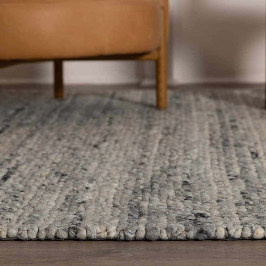Close-up of the hand-woven Olisa Gray Wool Area Rug showing its light gray and natural gray tones and textured design. Styleshot