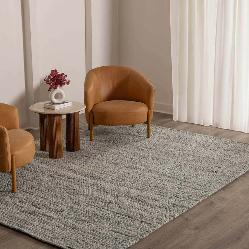 Living room scene with tan leather chairs and Olisa Gray Wool Area Rug. Neutral tones create a calming, transitional space. Roomscene-Rectangle