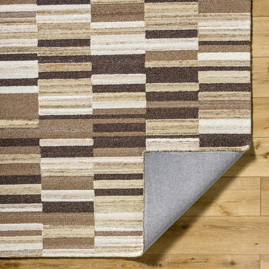 Close up of Amrita Beige Area Rug showing a geometric block pattern in beige, cream, tan, and brown wool. Fold