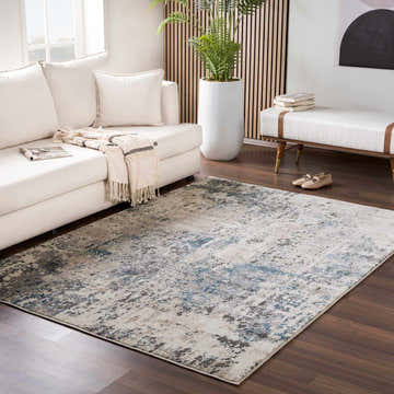 Living room scene with a white sofa and the Enoree Area Rug in black, beige, and blue adding a contemporary style. Roomscene-Rectangle