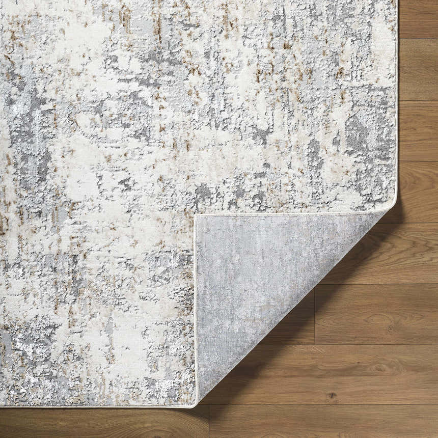 Close-up of the Avital Neutral Abstract Area Rug showing charcoal, gray, light brown, and white tones on wood flooring. Fold