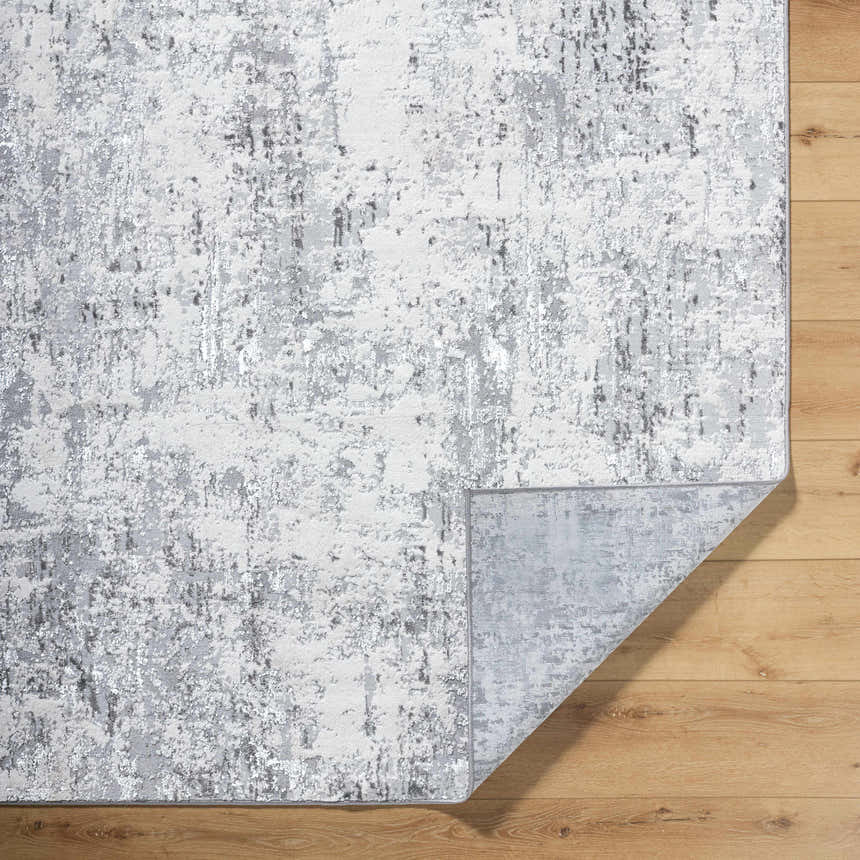 Close-up of the Avital Area Rug. Contemporary style in gray, charcoal, black, and white. Machine woven texture. Fold