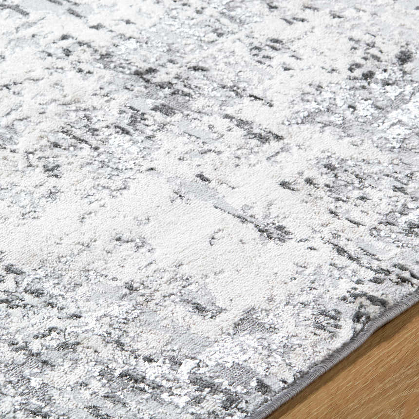 Close-up of the Avital Area Rug, a machine-woven rug with a contemporary black, charcoal, and white abstract design. Texture