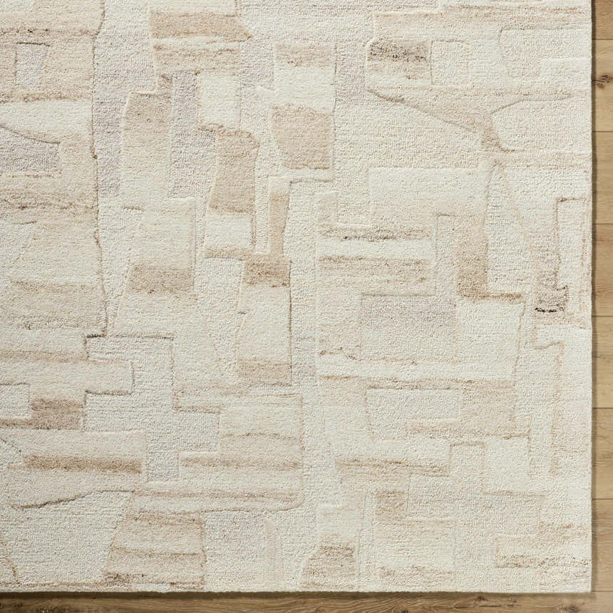 Close-up of the hand-tufted Aintza Area Rug. Beige, cream, ivory, and tan wool rug with a geometric pattern. Farmhouse style. Corner