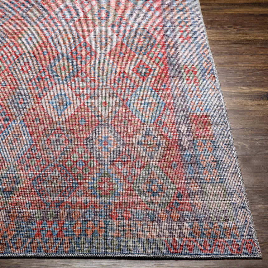 Close up of Ranao Washable Area Rug. Traditional design in blue, red, peach, and green on dark wood floor. Front