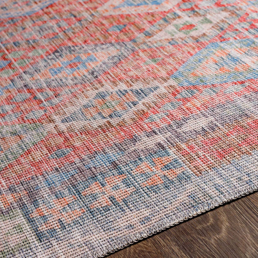 Close up of the Ranao Washable Area Rug showing its woven texture and colors: blue, green, peach, red, and taupe. Texture