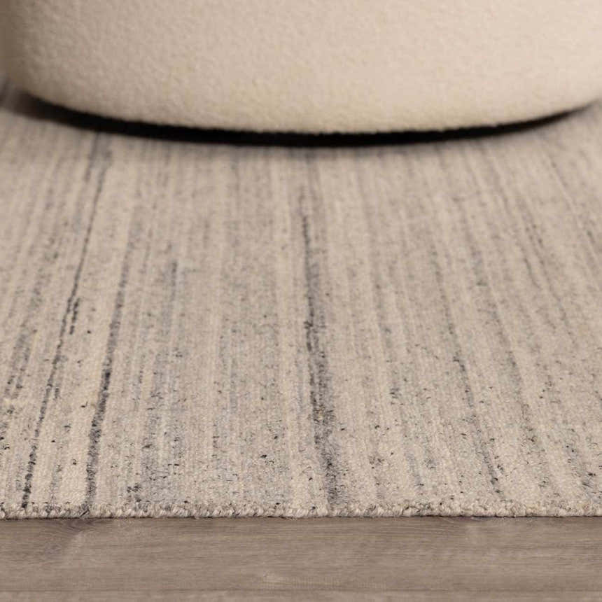 Close-up of the hand-tufted Capote Charcoal Area Rug, showing its wool texture and subtle slate gray stripes. Roomscene-Rectangle