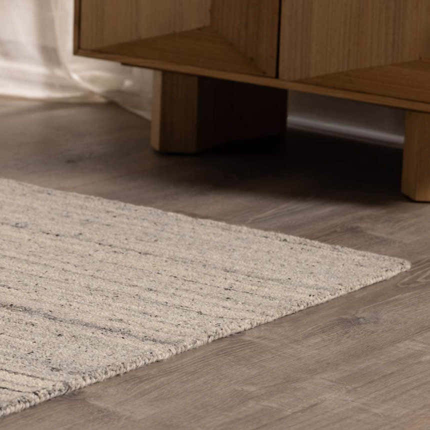 Close-up of the hand-tufted Capote Charcoal Area Rug showing its ivory, slate gray, and charcoal tones and wool texture. Roomscene-Rectangle