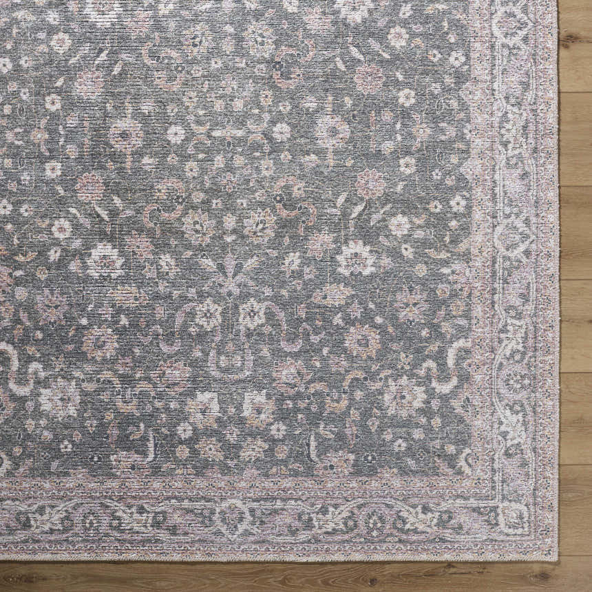 Close-up of the Anando Washable Area Rug. Features a traditional floral pattern in cream, pale pink, and green on a gray background. Corner