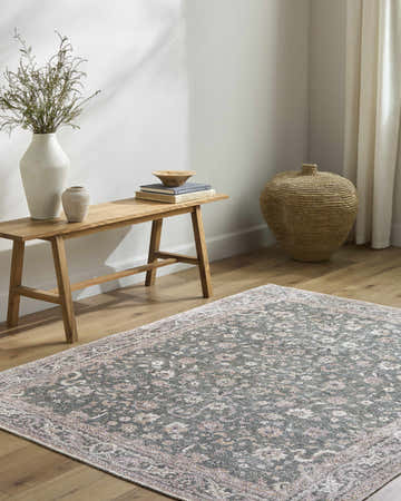 Entryway with a wood bench, woven basket, and Anando Washable Area Rug in cream, green, and pale pink. Roomscene-Rectangle