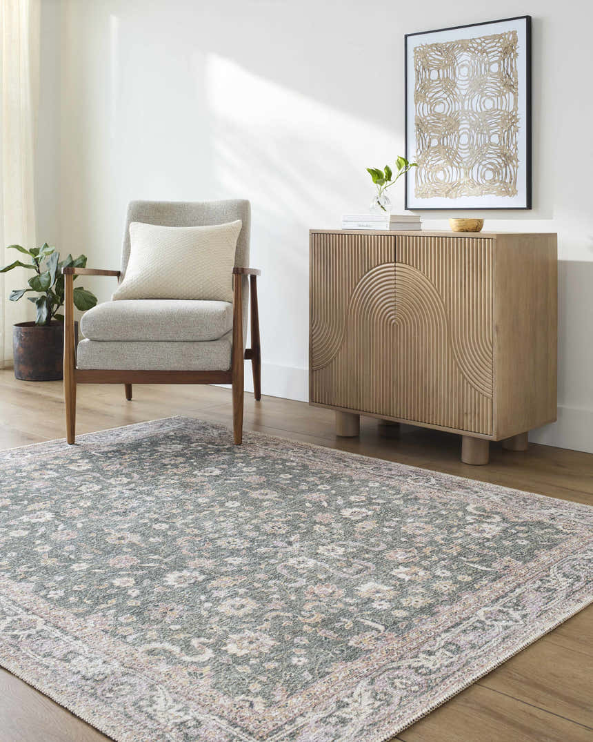Living room scene with the Anando Washable Area Rug in cream, green, and pale pink, styled with a gray chair and wood cabinet. Roomscene-Rectangle