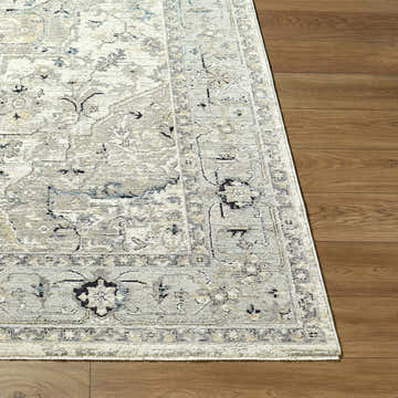 Close-up of the Ayzize Ivory Area Rug showing its traditional pattern and colors on a wood floor. Front