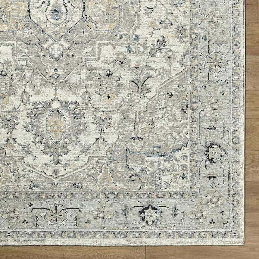 Close up of the Ayzize Ivory Area Rug showing its traditional charcoal, ivory, and blue floral pattern and texture. Corner