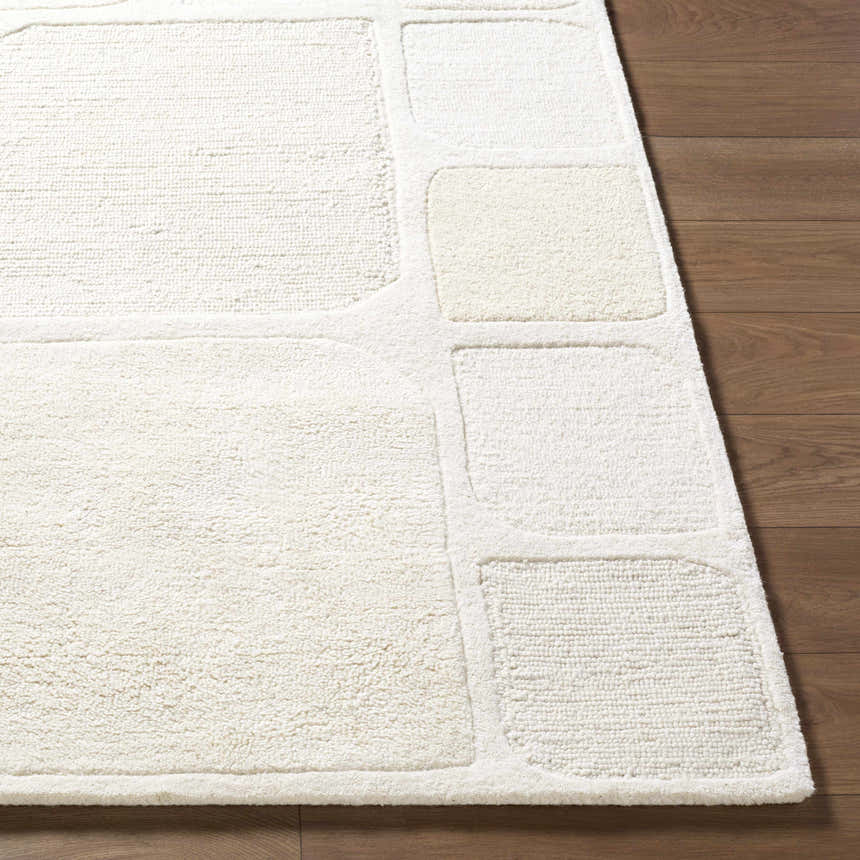 Close-up of the hand-tufted Antwan Area Rug. Cream and beige wool rug with a contemporary geometric pattern. Front