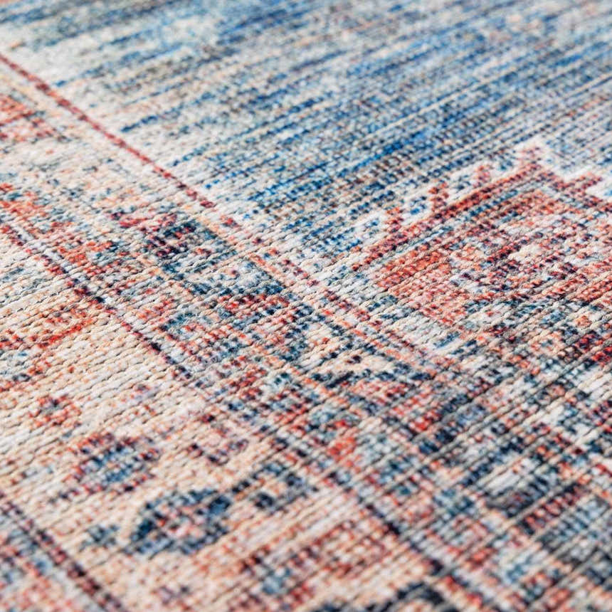 Close-up of the Baltinglass Rust & Blue Washable Area Rug, showing its traditional pattern and chenille texture. Texture