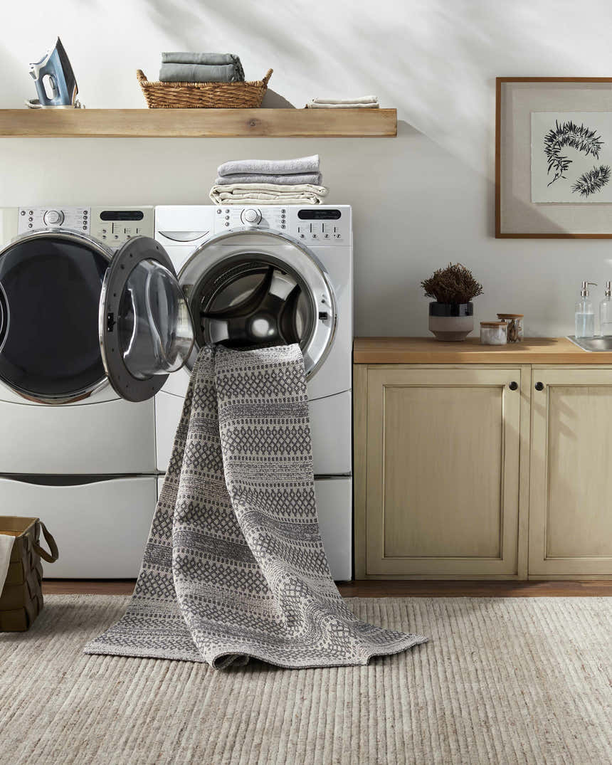 Laundry room scene with Ringtown Washable Area Rug being removed from the washing machine. Charcoal and ivory rug. Washing-Machine