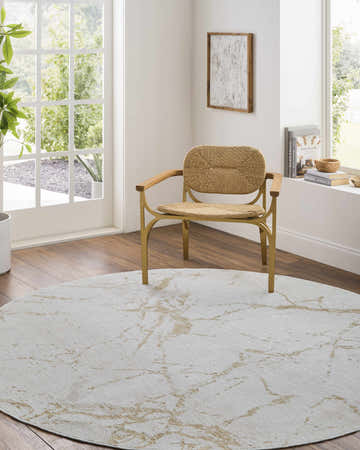 Bright living room with a round Rasia Luxe Rug in cream and tan under a modern chair. Roomscene-Round