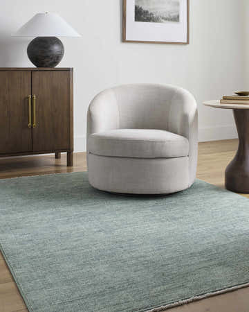 Living room scene with a Livabliss x Galey Alix Maria Elena II rug, cream chair, wood cabinet, and neutral decor. Roomscene-Rectangle