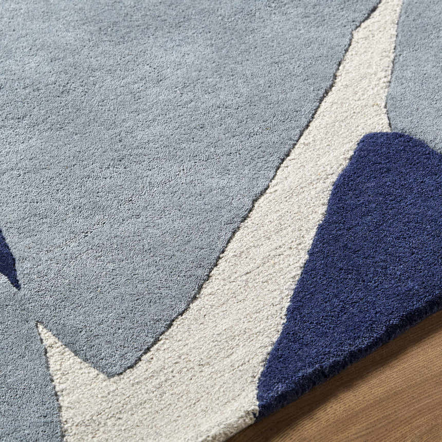 Close-up of the Robbins Modern Blue Wool Rug, featuring a geometric pattern in blue, light slate, and white. Texture