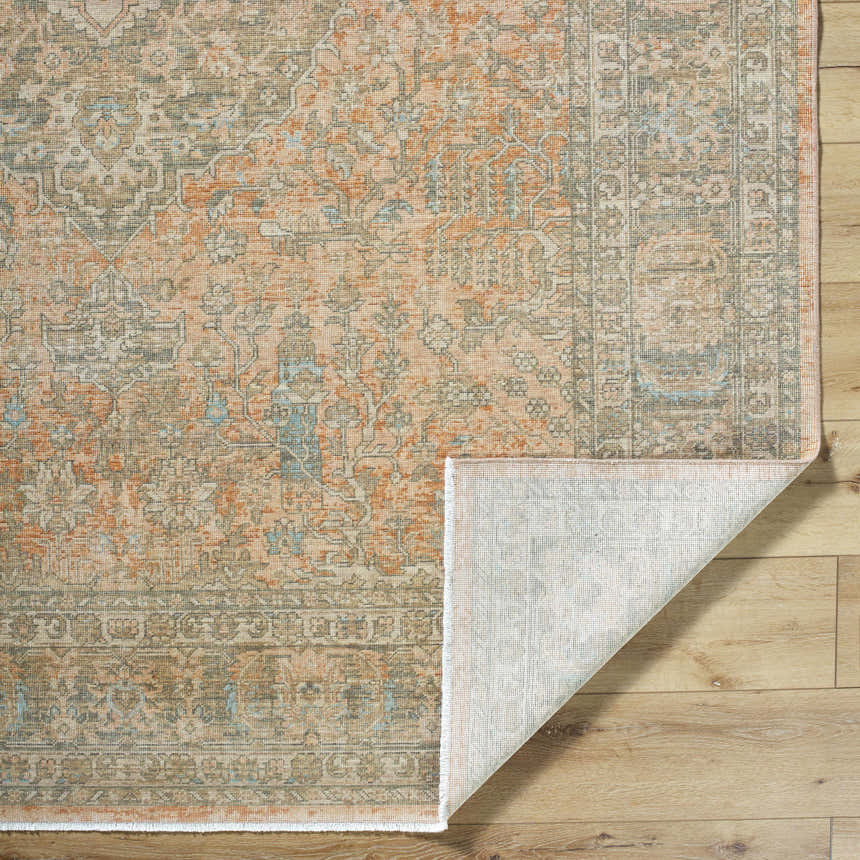 Close-up of Becki Owens x Livabliss Renaissance BORI-2301 rug. Beige, denim, coral, and tan traditional wool rug pattern. Fold