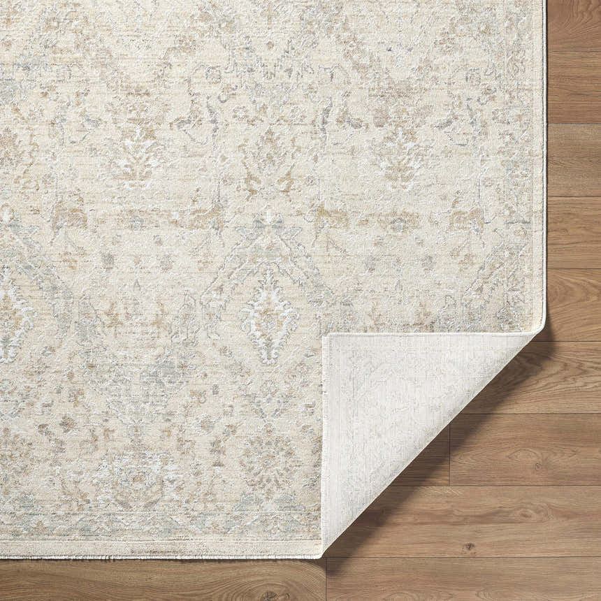 Close-up of the Almaas Cream rug showing its traditional pattern and luxe texture on a wood floor. Fold